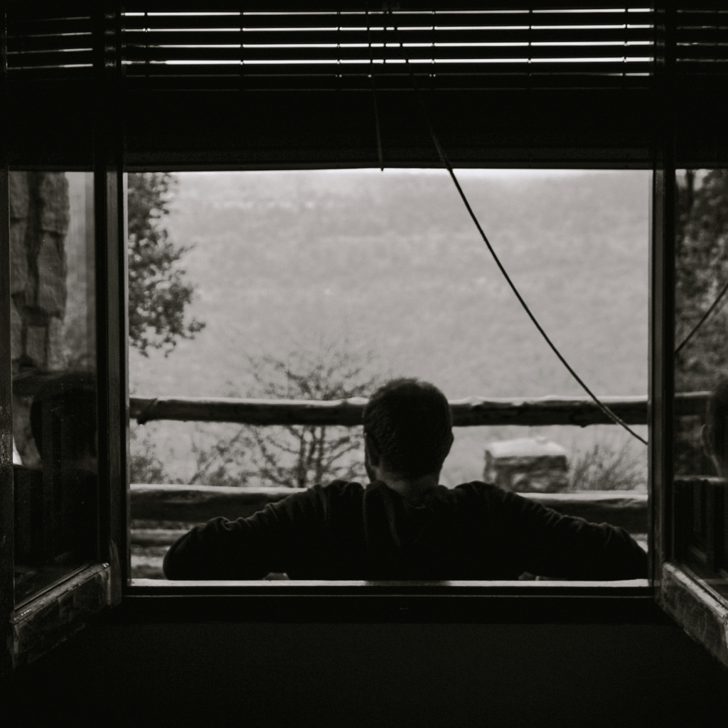 조용한 밤, 창가에 앉아 숨을 고르는 남성의 실루엣