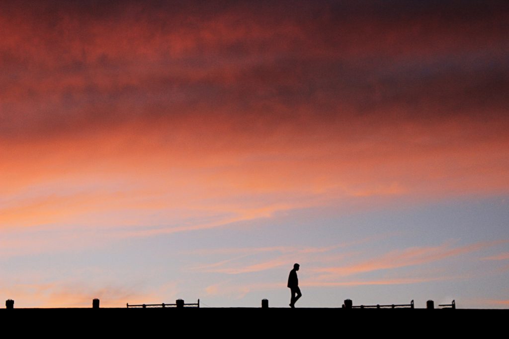 저녁 노을 속을 산책하는 사람